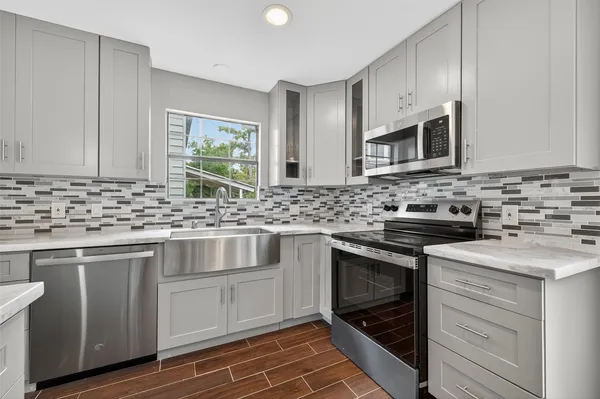 a kitchen with stainless steel appliances granite countertop a sink stove and cabinets