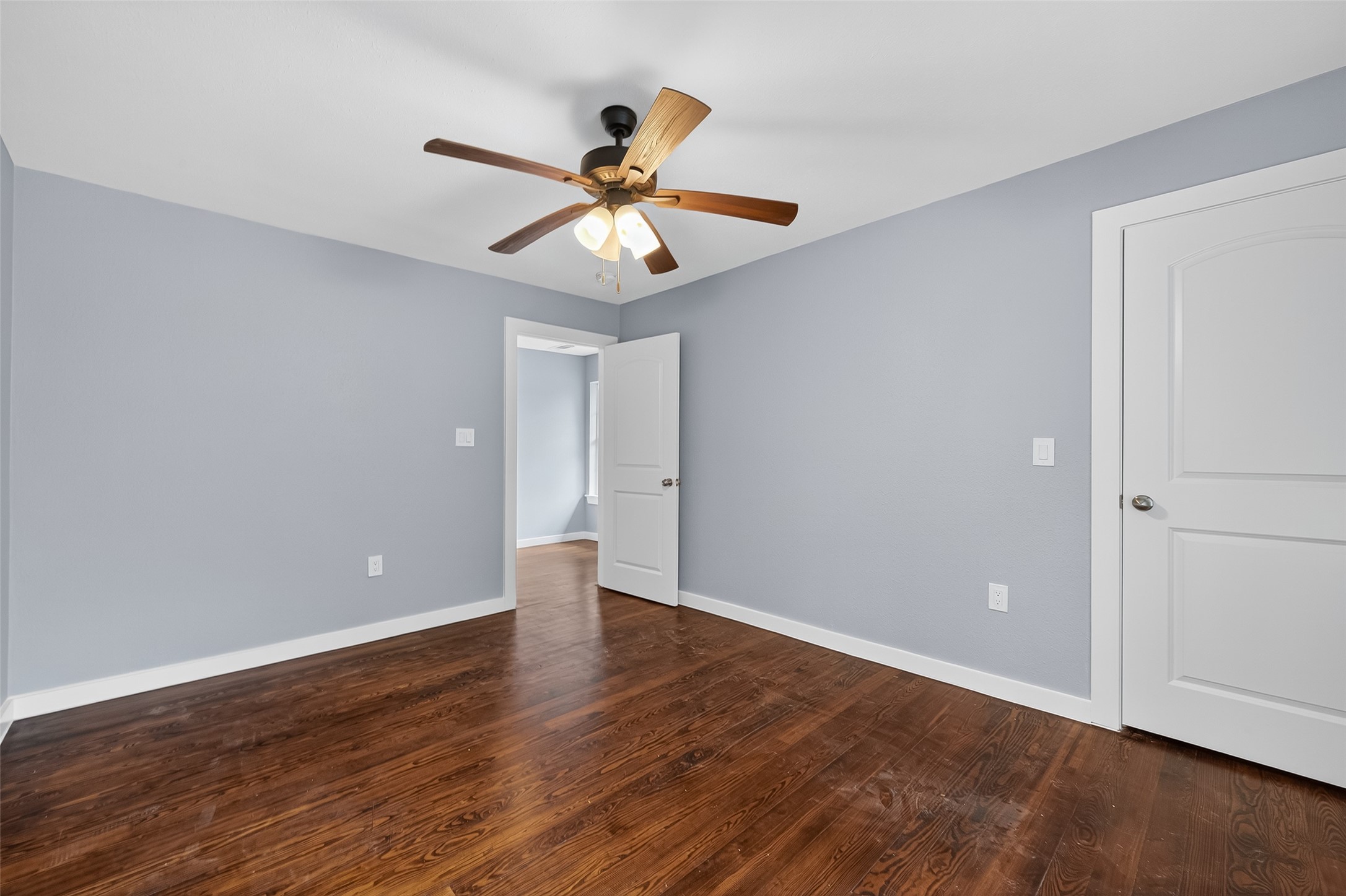 1933 Santa Rosa Street Houston, TX 77023 - Photo 25 of 44 a view of an empty room with wooden floor and a ceiling fan