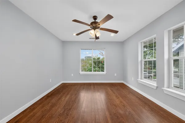 a view of room with window ceiling fan and hardwood floor