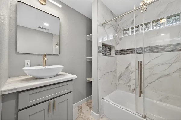 a bathroom with a bathtub a sink a vanity and a shower