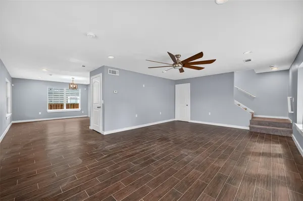 a view of empty room with wooden floor and window