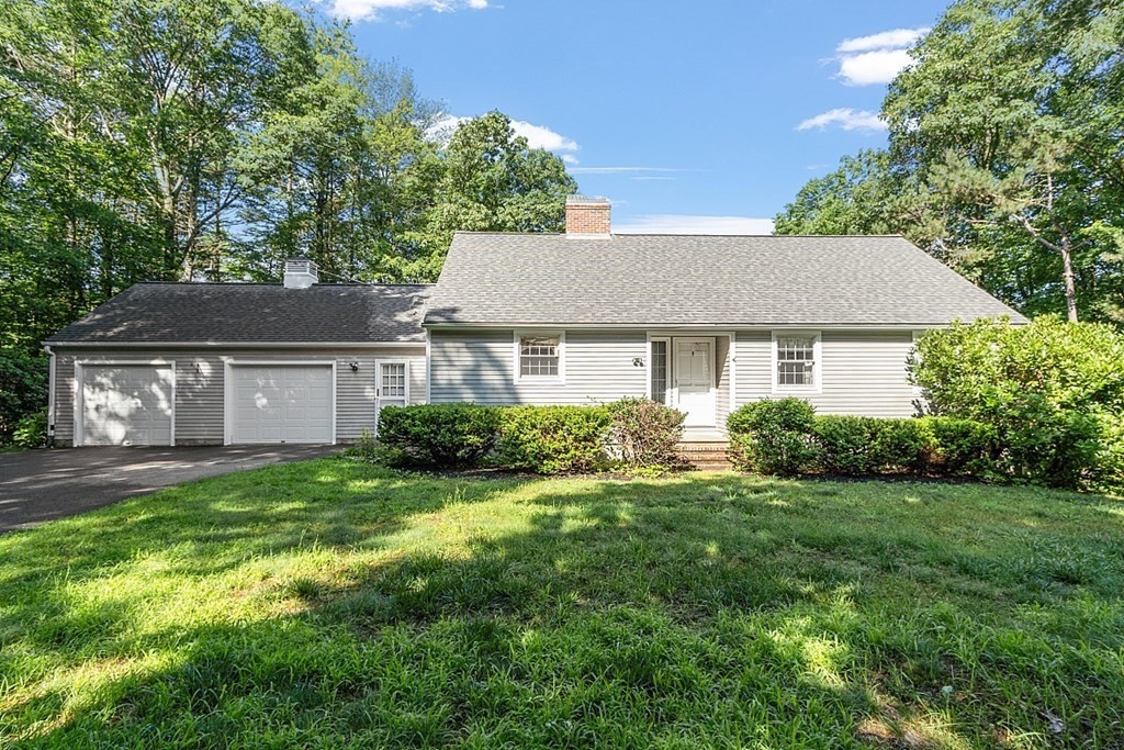 a front view of a house with a yard and trees