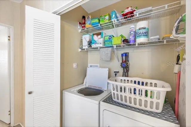 a kitchen with a refrigerator and white cabinets
