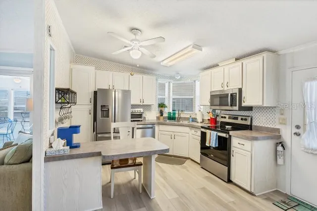 a kitchen with stainless steel appliances a stove refrigerator sink and microwave