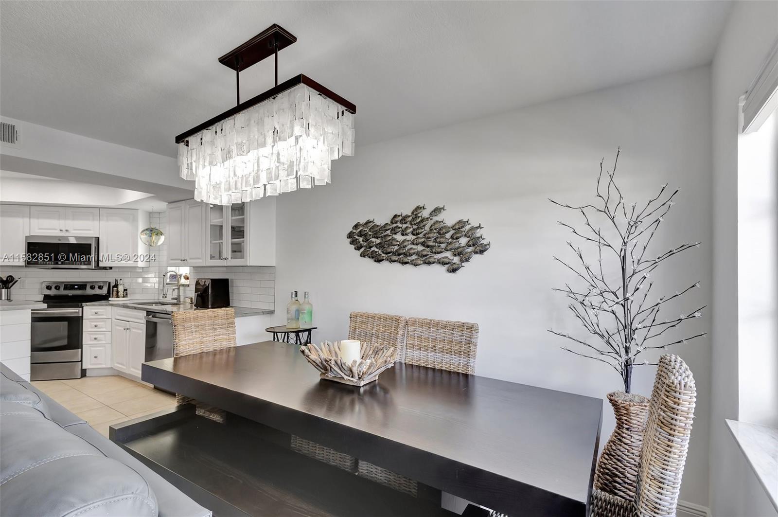 237 Seabreeze Circle Jupiter, FL 33477 - Photo 14 of 63 a view of a dining room with furniture a chandelier and wooden floor