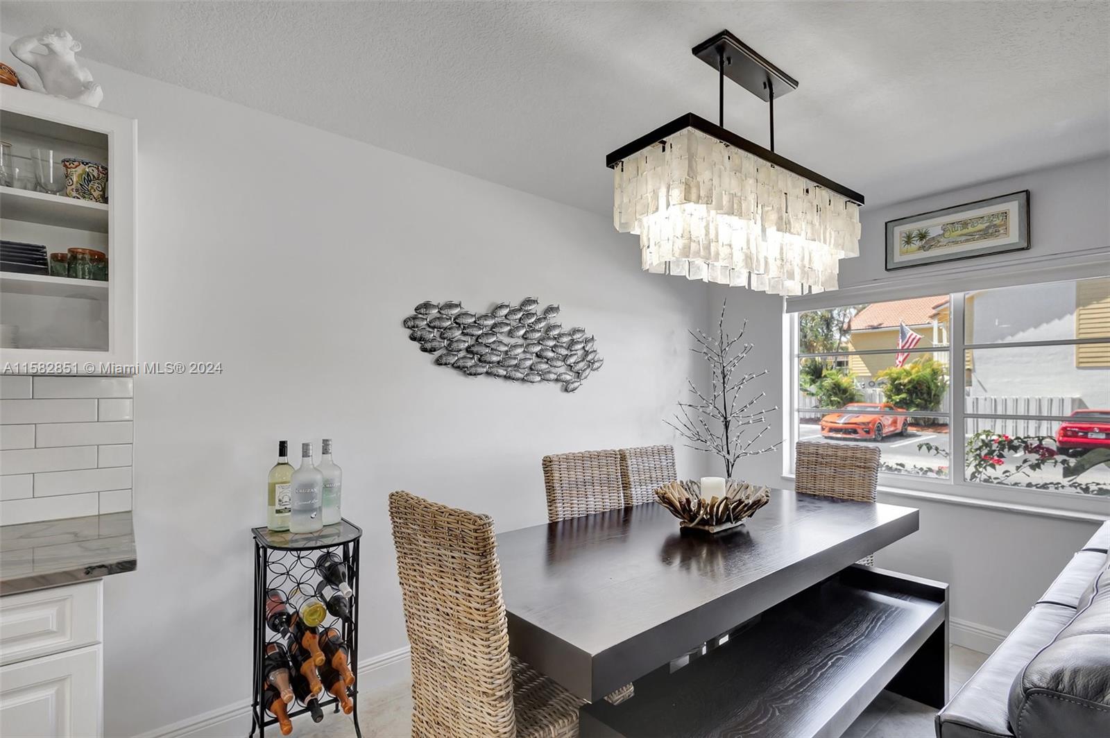 237 Seabreeze Circle Jupiter, FL 33477 - Photo 15 of 63 a view of a dining room with furniture a chandelier and wooden floor