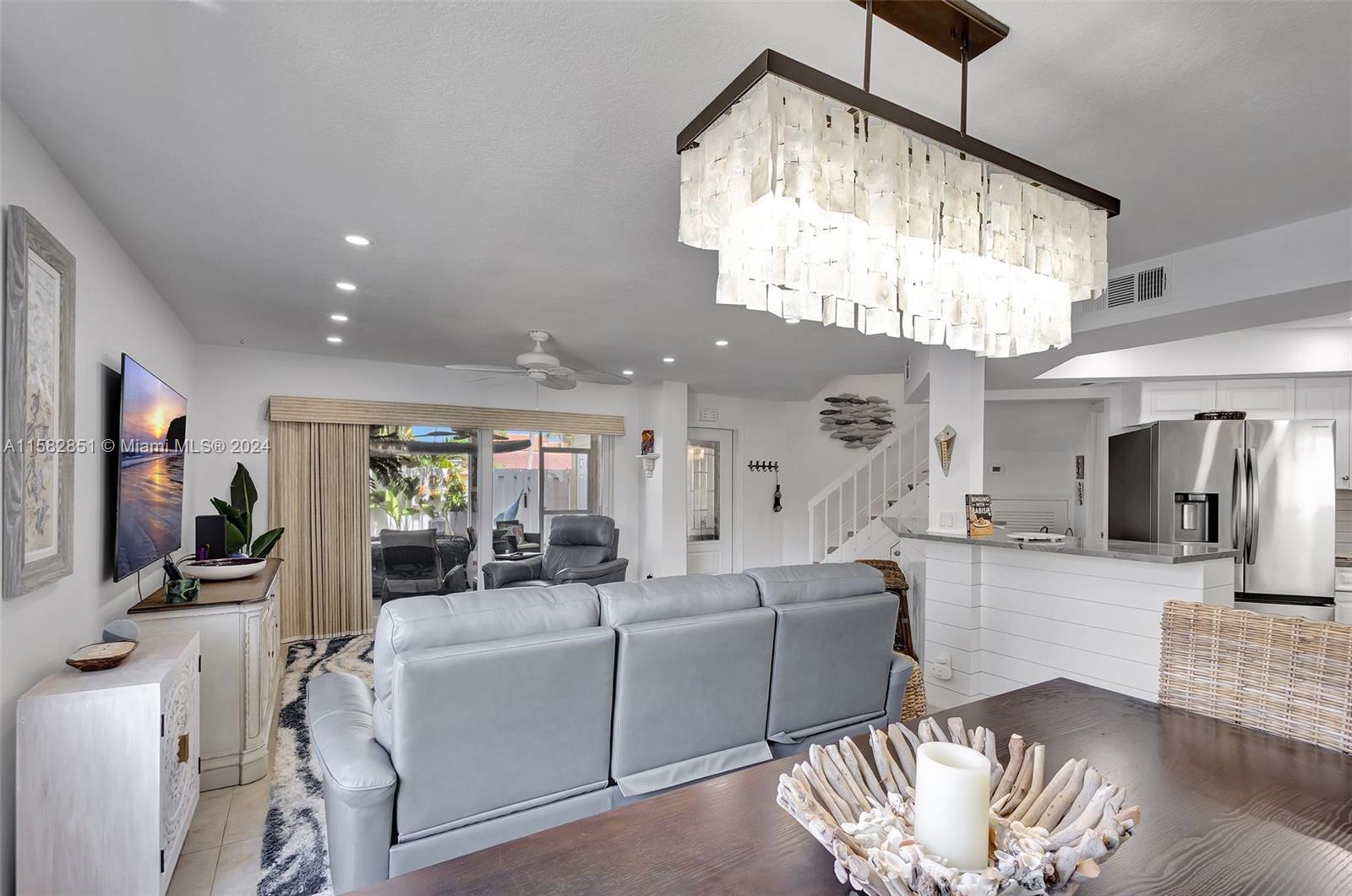 237 Seabreeze Circle Jupiter, FL 33477 - Photo 17 of 63 a living room with furniture a chandelier and a flat screen tv