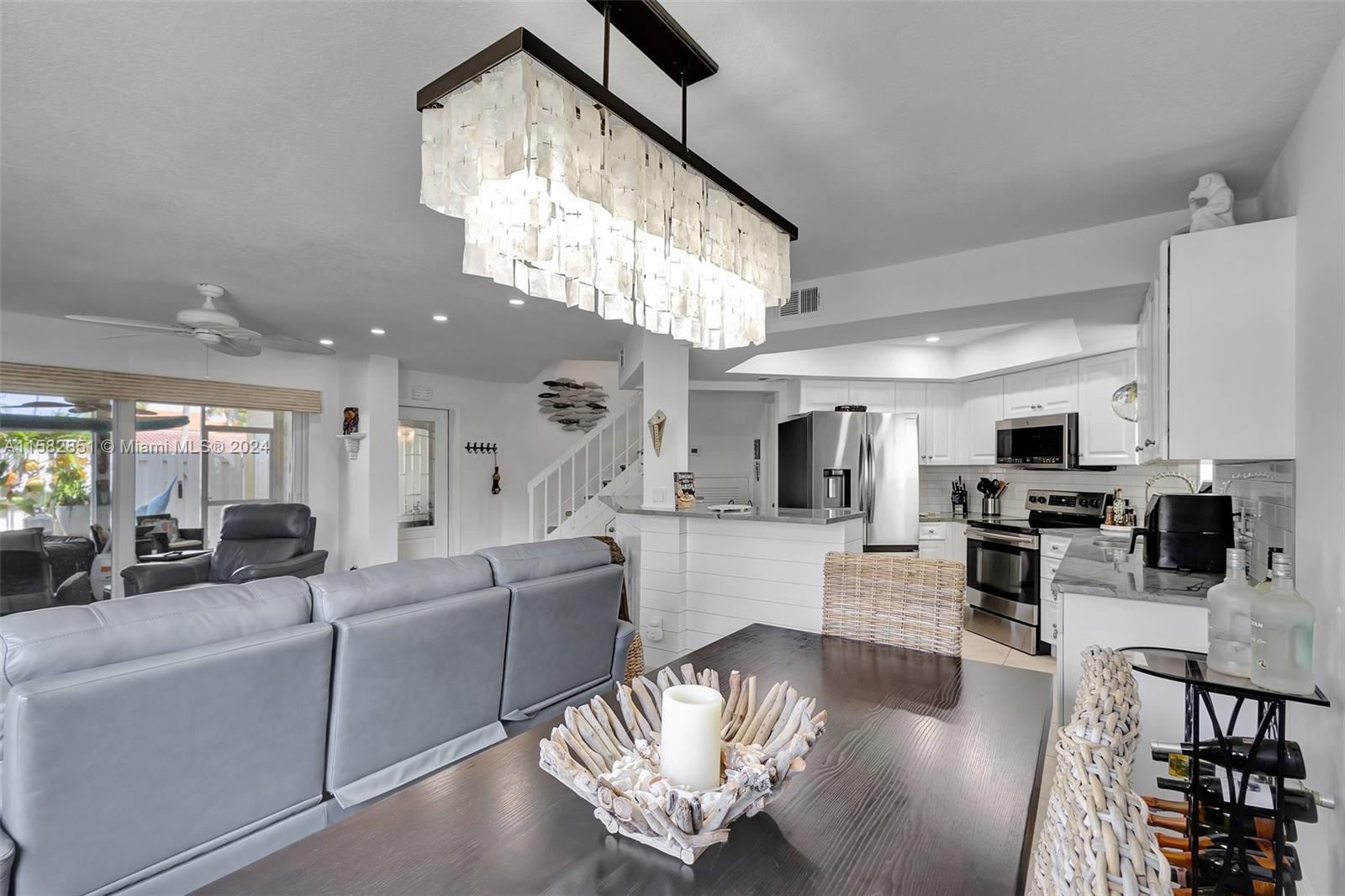 237 Seabreeze Circle Jupiter, FL 33477 - Photo 18 of 63 a living room with furniture a large window and a chandelier