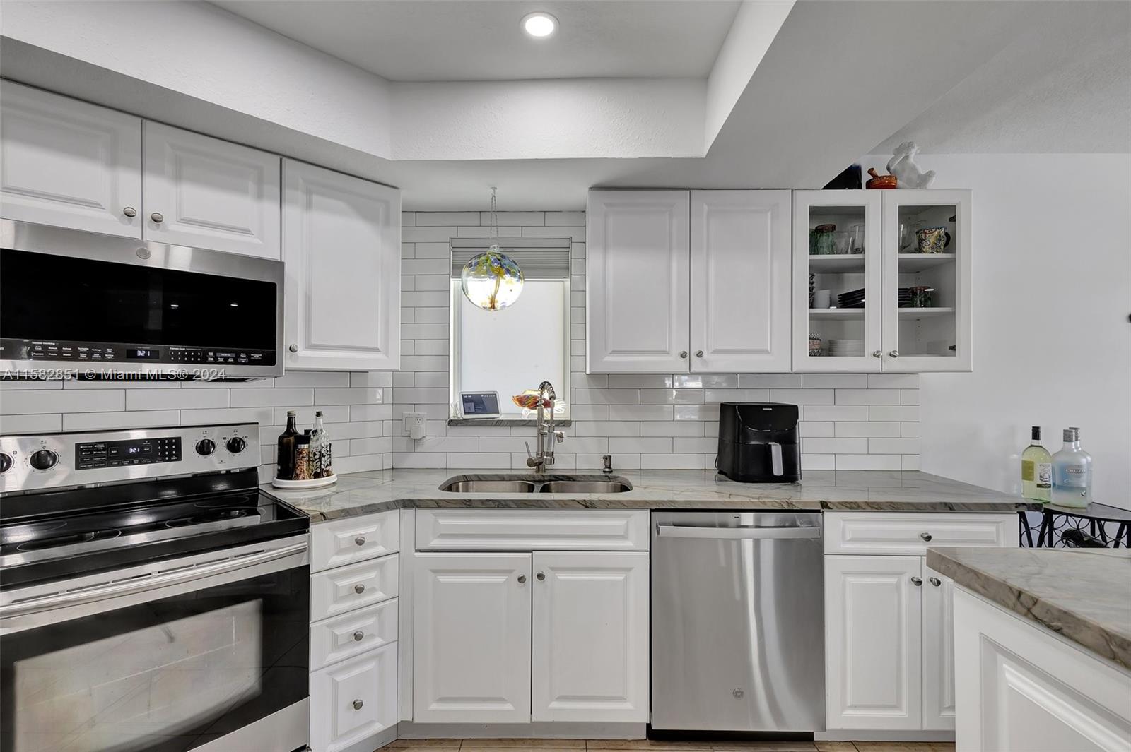 237 Seabreeze Circle Jupiter, FL 33477 - Photo 22 of 63 a kitchen with white cabinets and appliances