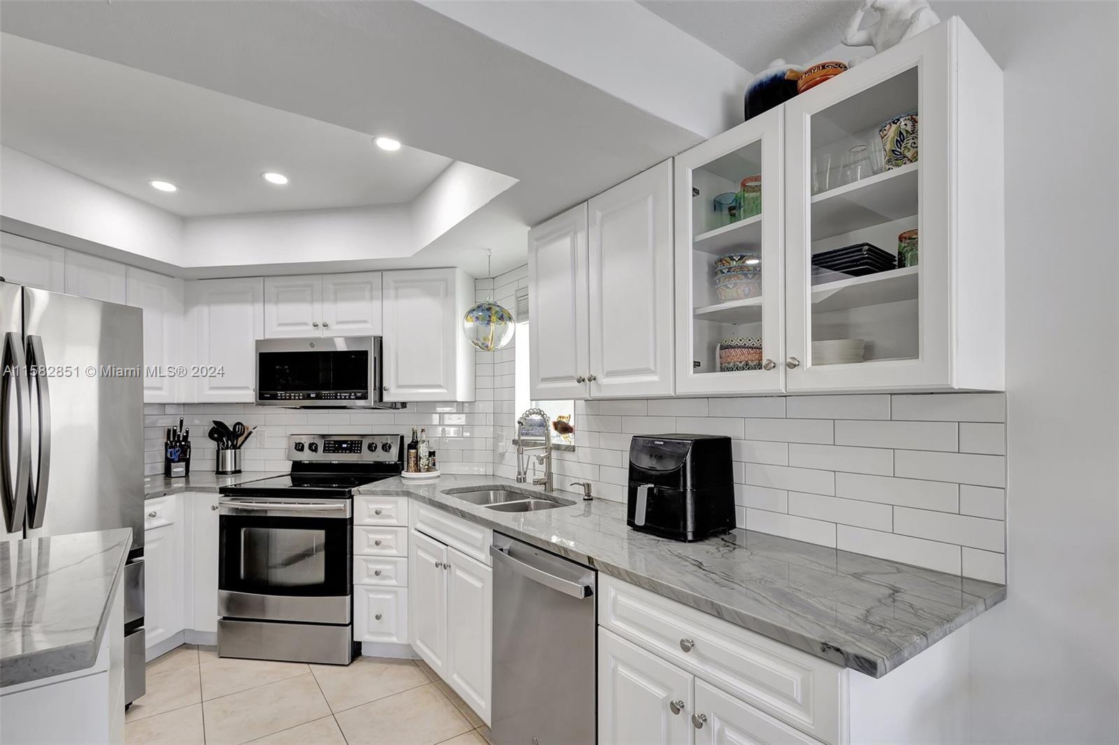 237 Seabreeze Circle Jupiter, FL 33477 - Photo 26 of 63 a kitchen with a stove and a refrigerator