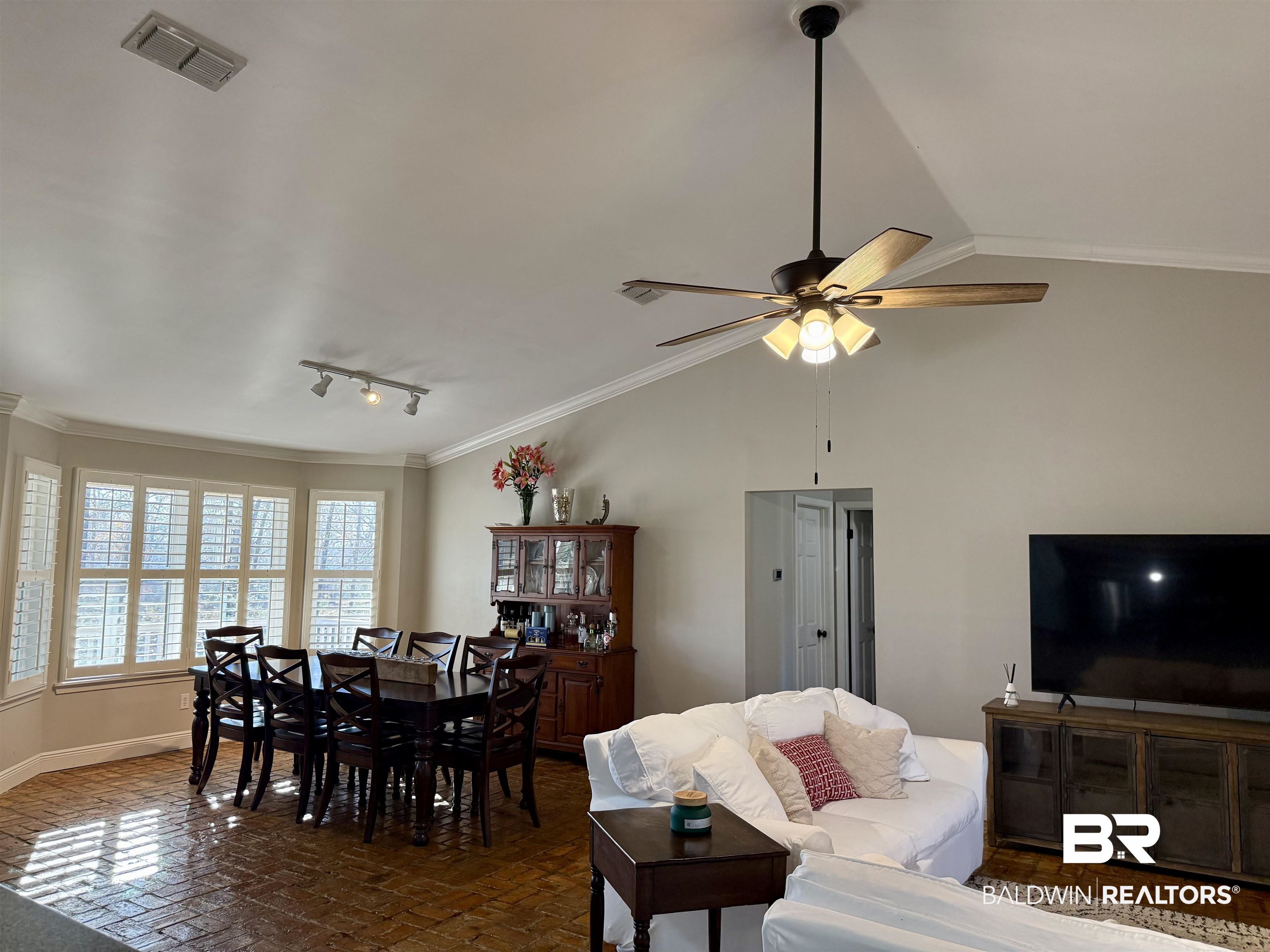 5646 Foshee Road Brewton, AL 36426 - Photo 7 of 37 Living room featuring vaulted ceiling, ornamental molding, track lighting, and a ceiling fan