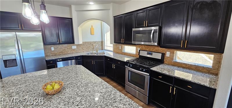6302 Jackson Spring Road Las Vegas, NV 89118 - Photo 10 of 48 A contemporary kitchen showcasing dark cabinetry, granite countertops, and stainless steel appliances for a polished culinary experience.