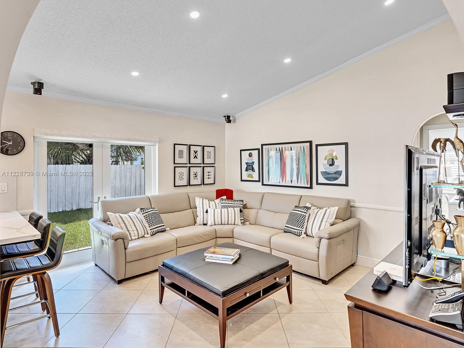 11291 Southwest 62nd Terrace Miami, FL 33173 - Photo 25 of 65 a living room with furniture a rug and a wall painting