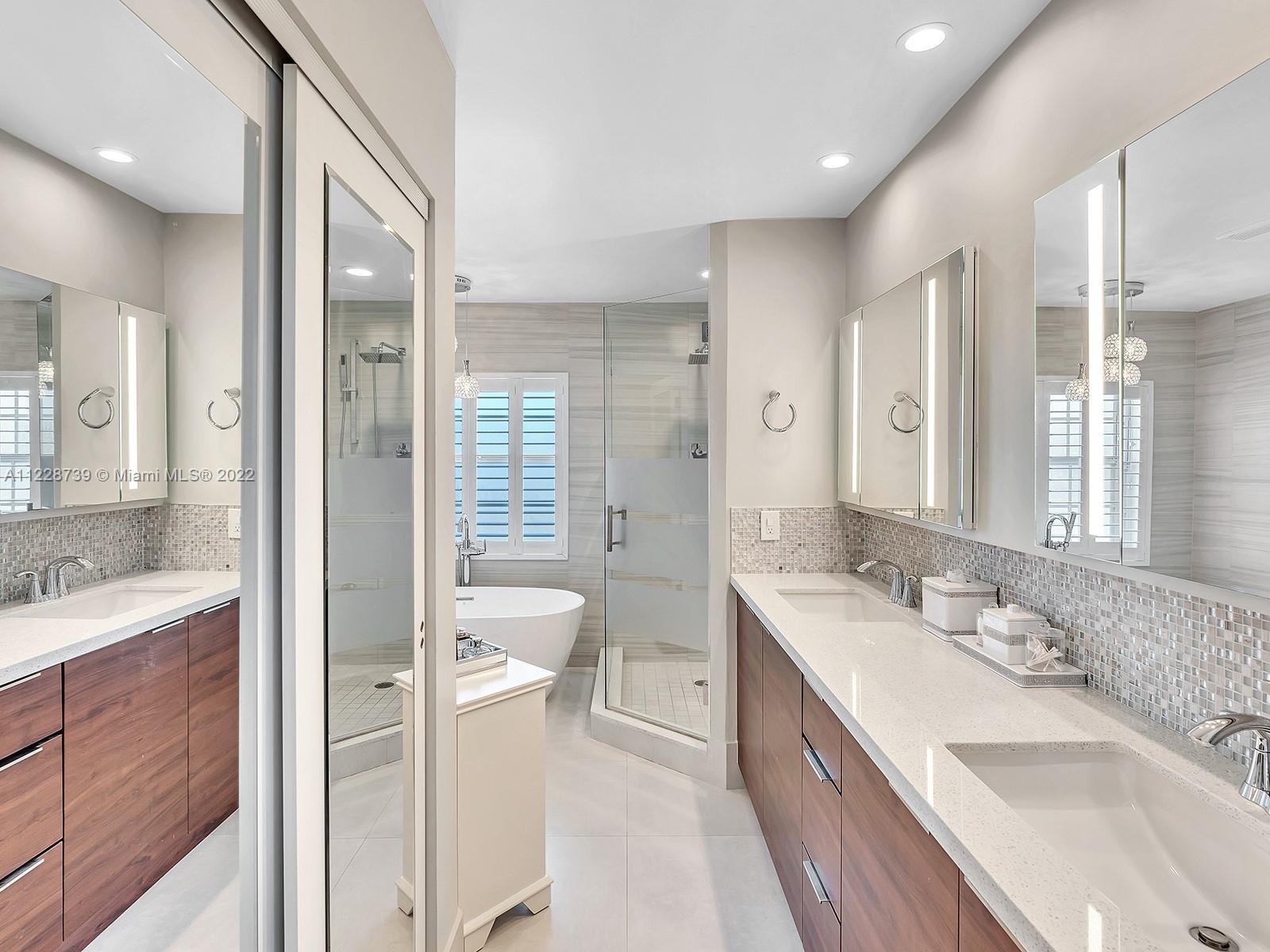 11291 Southwest 62nd Terrace Miami, FL 33173 - Photo 38 of 65 a spacious bathroom with a double vanity sink a large mirror and a shower