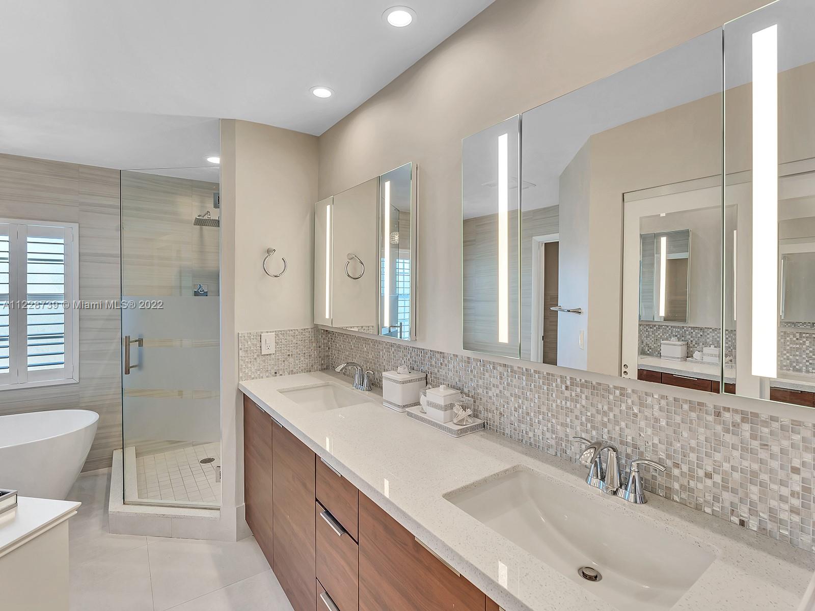 11291 Southwest 62nd Terrace Miami, FL 33173 - Photo 40 of 65 a bathroom with a sink double vanity granite tub shower and a mirror