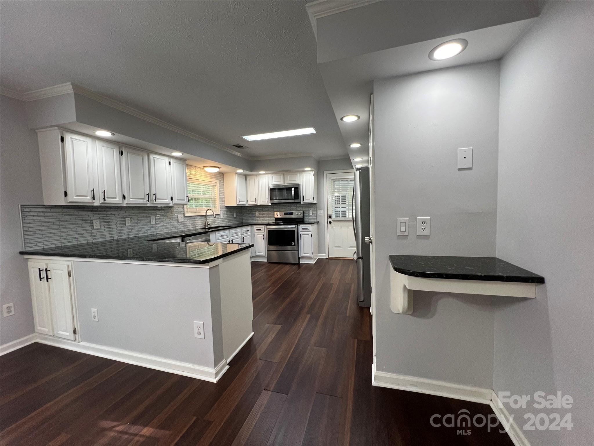 148 Riff Drive Forest City, NC 28043 - Photo 4 of 40 a kitchen with stainless steel appliances granite countertop a stove a sink and a refrigerator