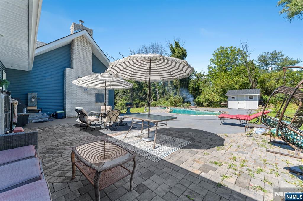 1 Rossi Drive Clinton, NJ 08809 - Photo 36 of 44 a view of a patio with a dining table and chairs with wooden floor and fence