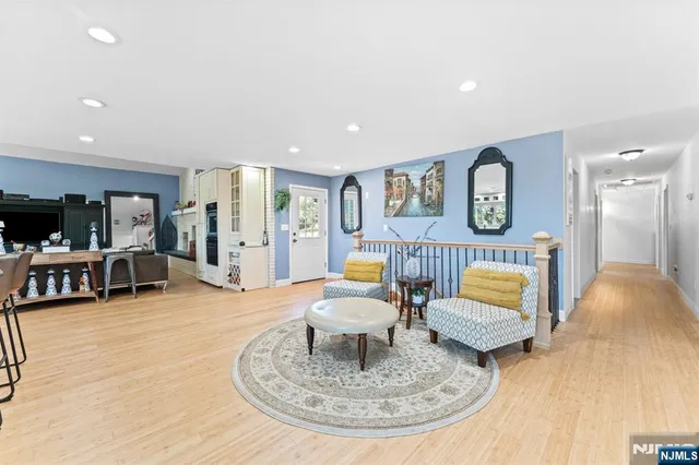 a kitchen with stainless steel appliances kitchen island granite countertop a stove top oven a sink a dining table and chairs with wooden floor