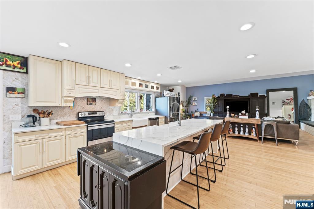 1 Rossi Drive Clinton, NJ 08809 - Photo 10 of 44 a kitchen with stainless steel appliances kitchen island granite countertop a stove top oven a sink a dining table and chairs with wooden floor