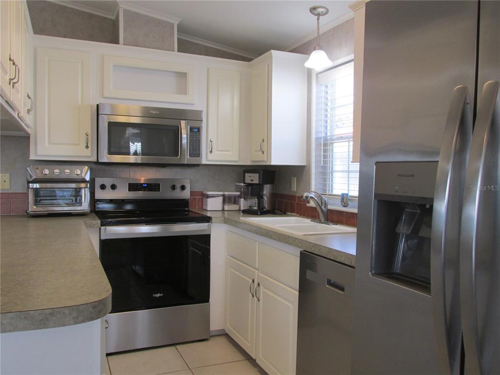 12 Saddle Bag Road Lake Wales, FL 33898 - Photo 8 of 34 a kitchen with stainless steel appliances granite countertop a stove a sink and a microwave