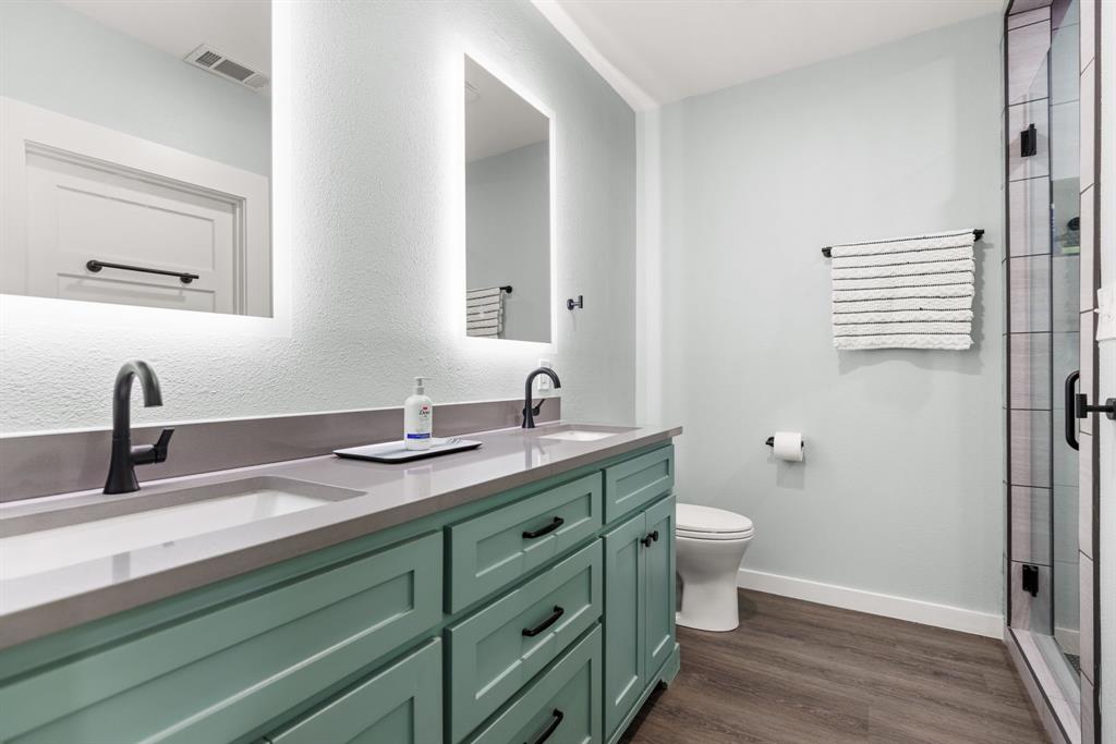300 Grellhesl Road West, TX 76691 - Photo 15 of 35 a bathroom with a double vanity sink toilet and a mirror