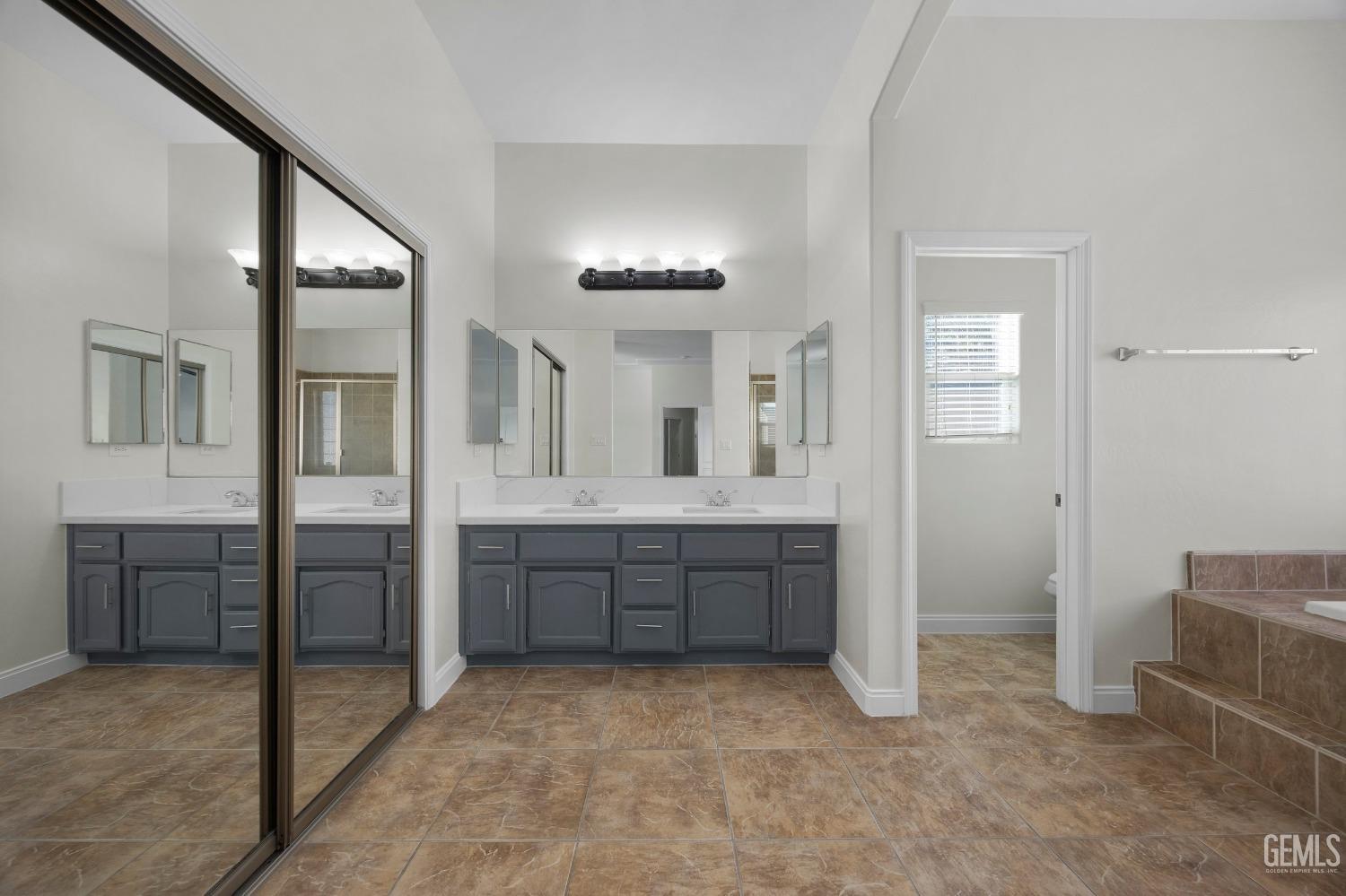 Undisclosed Address Bakersfield, CA 93313 - Photo 30 of 44 a spacious bathroom with a mirror vanity and bathtub