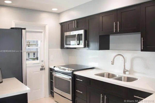 a kitchen with a sink cabinets and stainless steel appliances