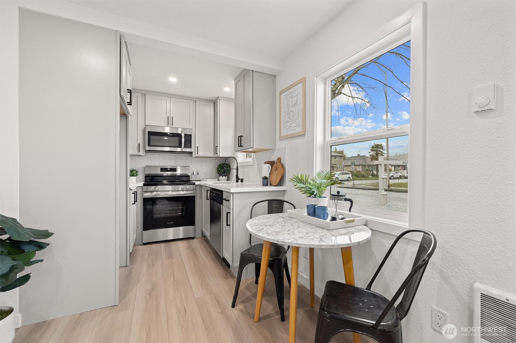 1310 North 3rd Street Renton, WA 98057 - Photo 6 of 16 a kitchen with kitchen island a dining table chairs stainless steel appliances and windows
