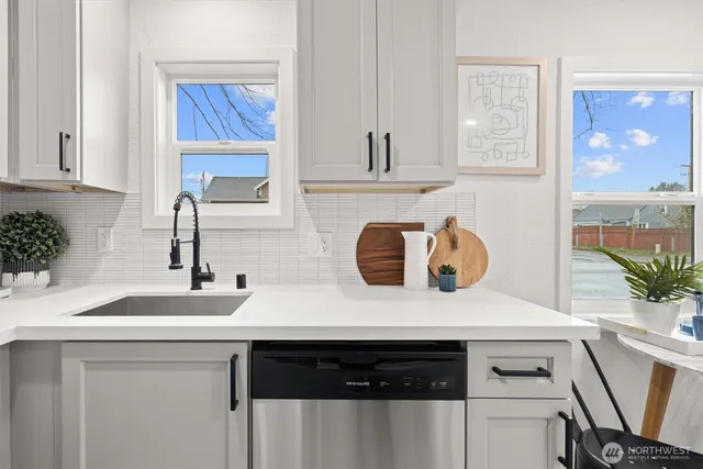 a kitchen with a sink dishwasher a stove and a microwave with wooden floor