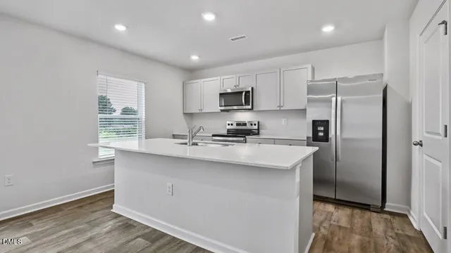 a kitchen with stainless steel appliances a sink stove and refrigerator