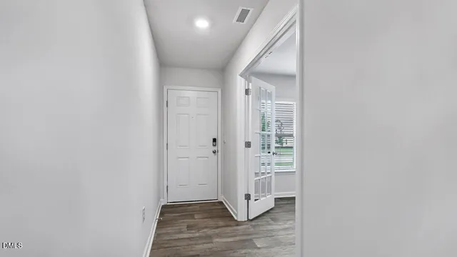 a view of a hallway with wooden floor and closet