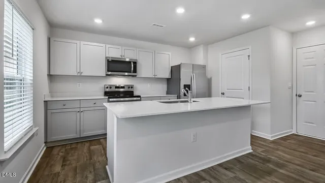 a kitchen with a sink stainless steel appliances and cabinets