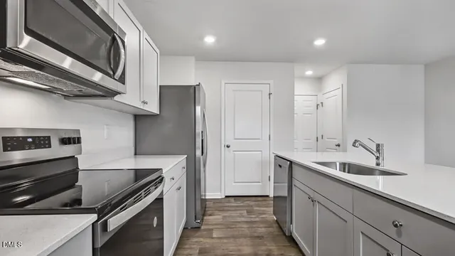 a kitchen with stainless steel appliances granite countertop a sink and a stove