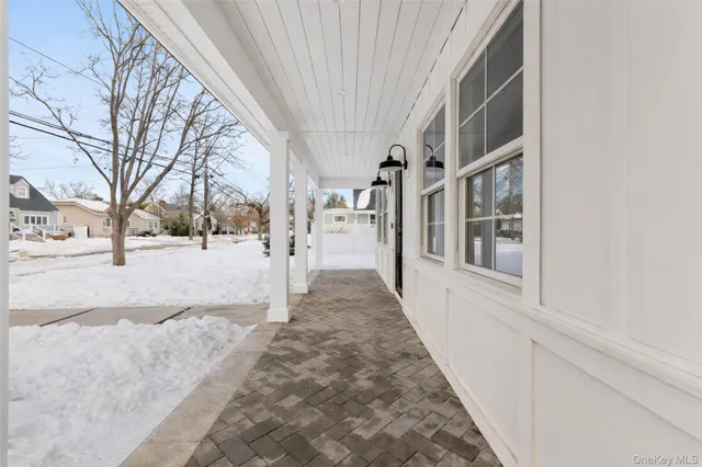 a view of a pathway of a house with snow on the road