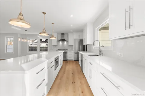 a large kitchen with kitchen island a large counter space a sink stainless steel appliances and cabinets