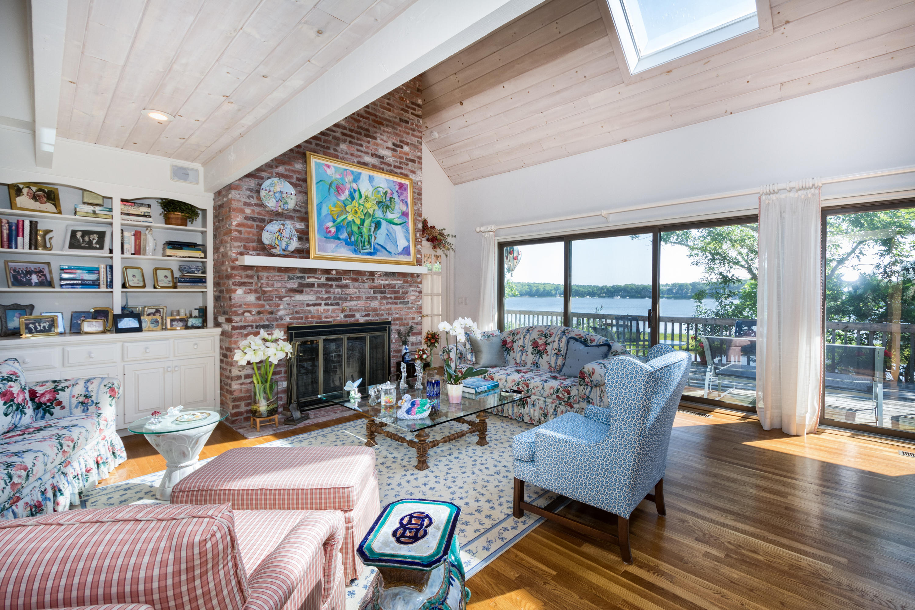 107 Tide Run Mashpee, MA 02649 - Photo 8 of 35 a living room with furniture a fireplace and a floor to ceiling window