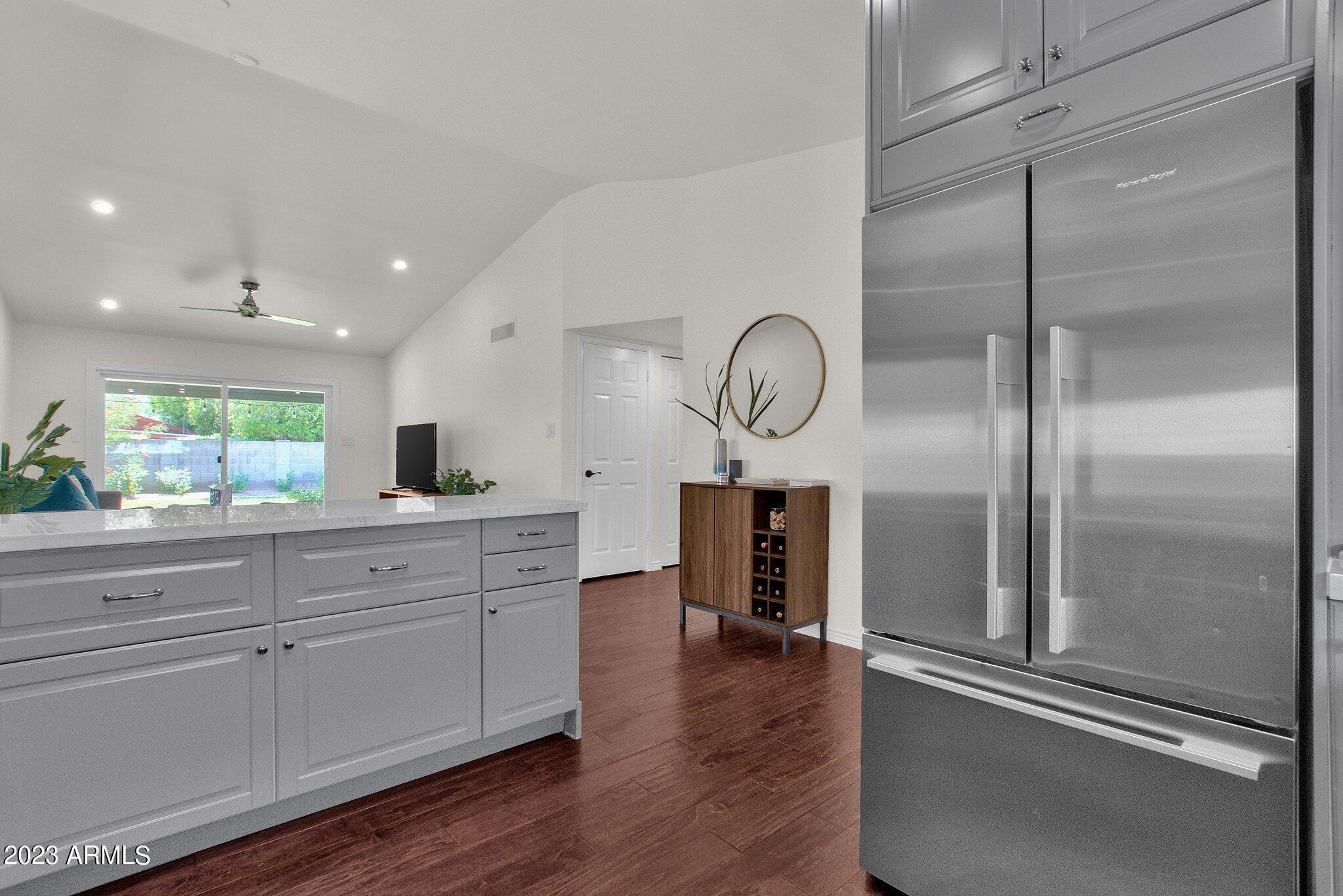 6867 East Phelps Road Scottsdale, AZ 85254 - Photo 15 of 20 a kitchen with stainless steel appliances granite countertop a refrigerator a stove and a wooden floors