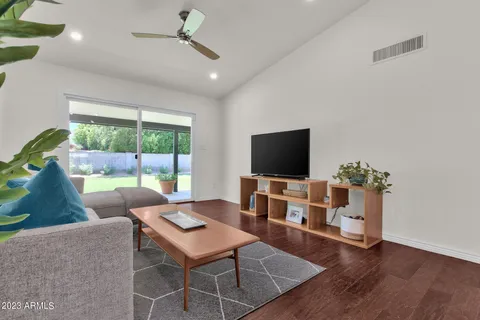 a living room with furniture a flat screen tv and a large window