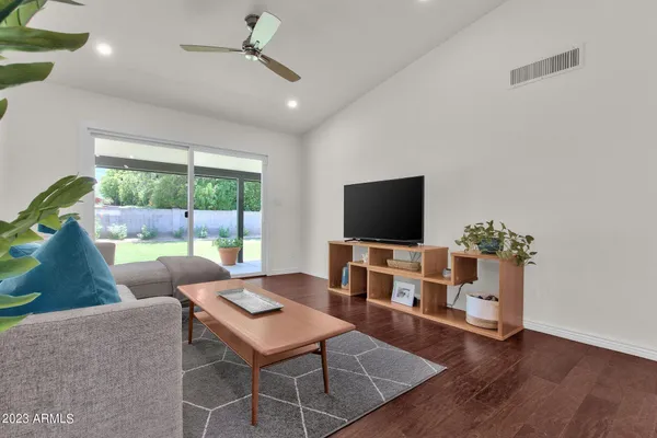 a living room with furniture a flat screen tv and a large window