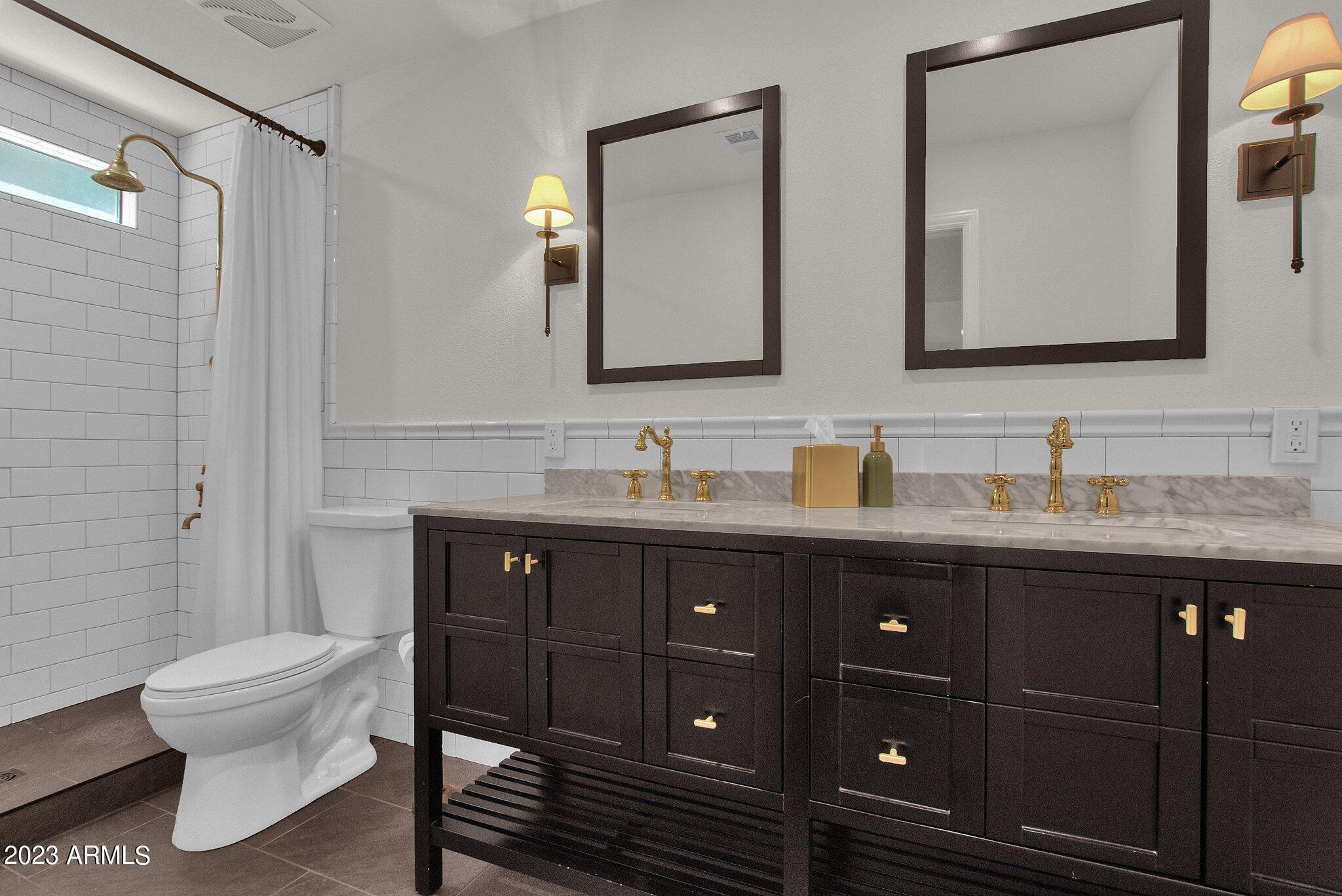 6867 East Phelps Road Scottsdale, AZ 85254 - Photo 9 of 20 a bathroom with a granite countertop toilet sink and mirror