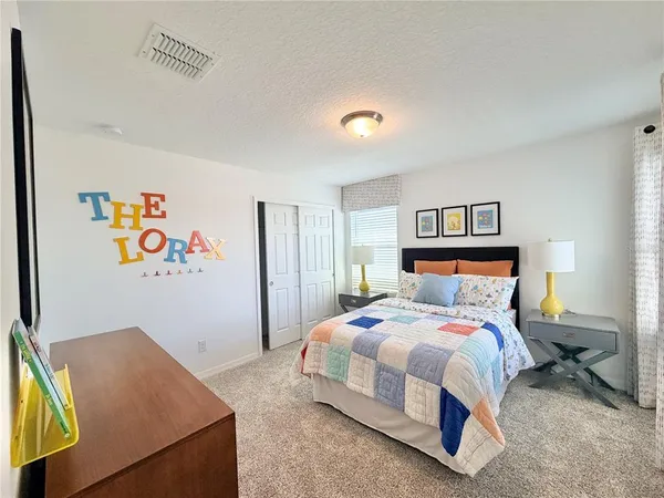a bedroom with a bed and painting on the wall
