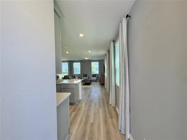 a view of a kitchen with kitchen island a stove a sink and a refrigerator with wooden floor