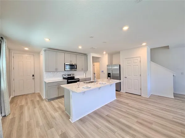 a kitchen with stainless steel appliances kitchen island granite countertop a stove and a refrigerator
