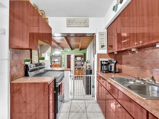 a kitchen with a sink a stove and cabinets