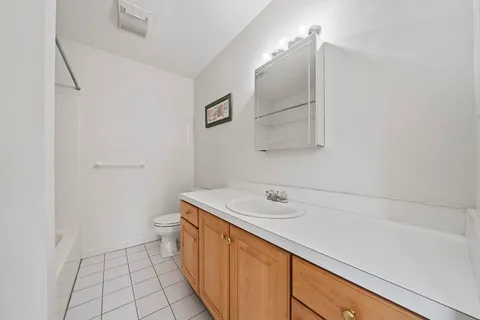 a bathroom with a sink a toilet and mirror