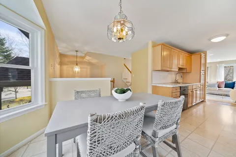 a dining room with furniture a chandelier and window