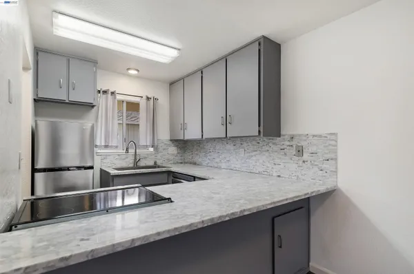 a kitchen with stainless steel appliances granite countertop a sink and a refrigerator