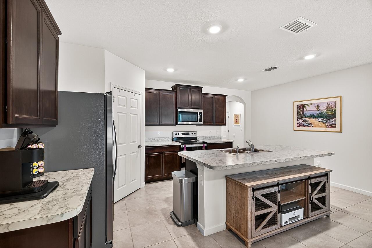 105 Cardinal Drive Sebastian, FL 32958 - Photo 15 of 45 a kitchen with stainless steel appliances granite countertop a stove top oven a sink dishwasher a refrigerator and a stove