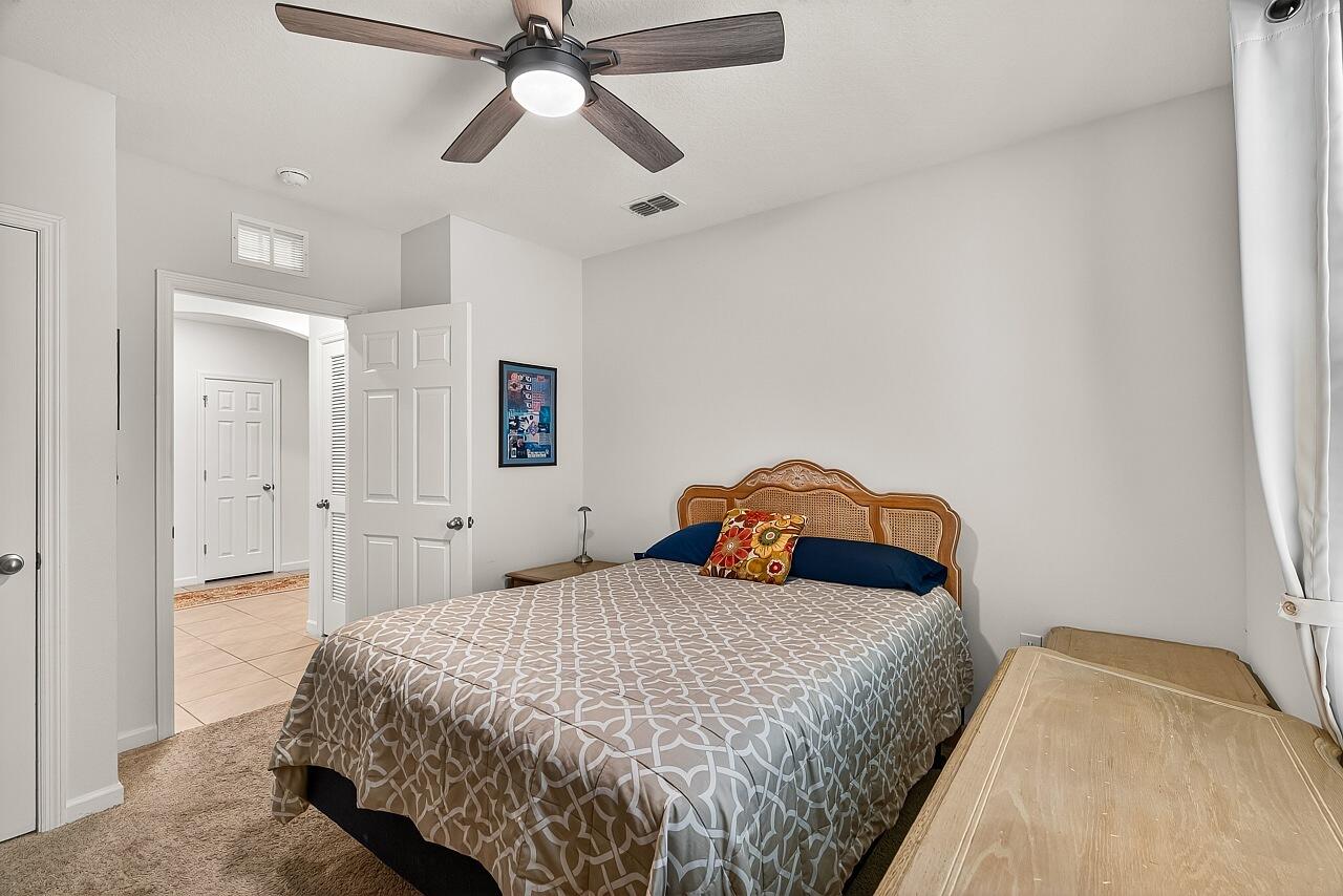 105 Cardinal Drive Sebastian, FL 32958 - Photo 35 of 45 a bedroom with a bed and a chandelier