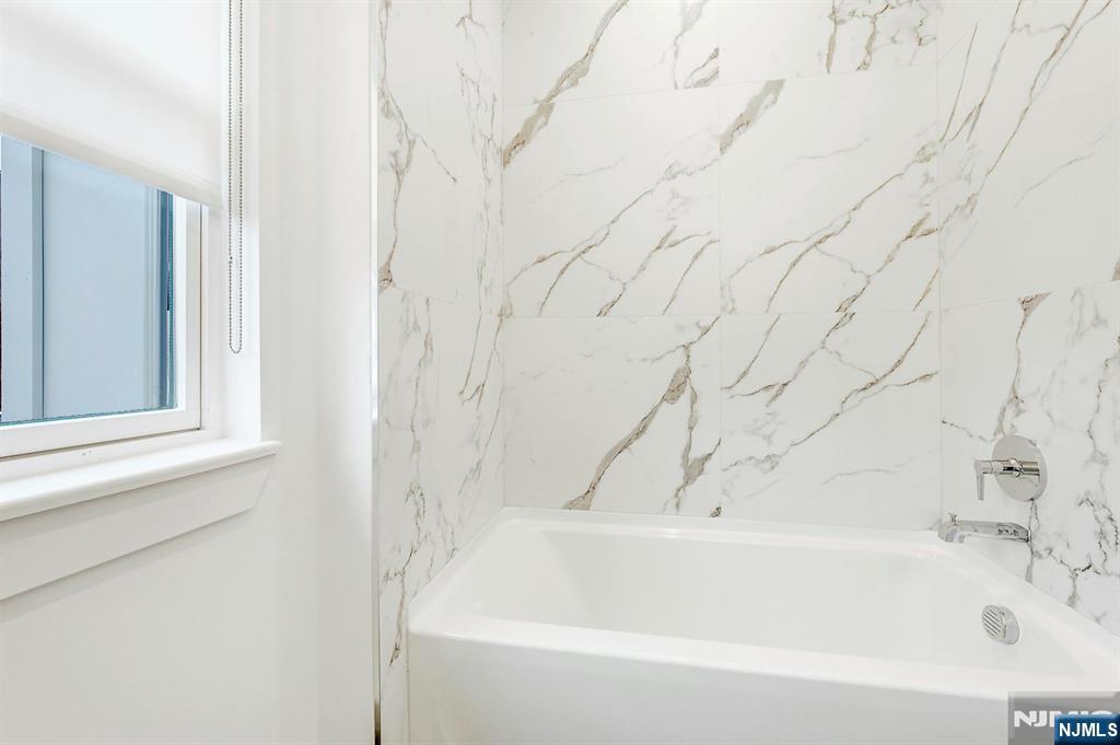 74 Clarendon Place, Unit 202 Hackensack, NJ 07601 - Photo 19 of 33 a bathroom with bathtub and shower